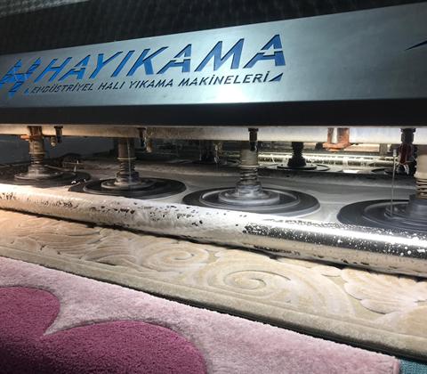 Halı yıkama makinesinde fırçalanan halı