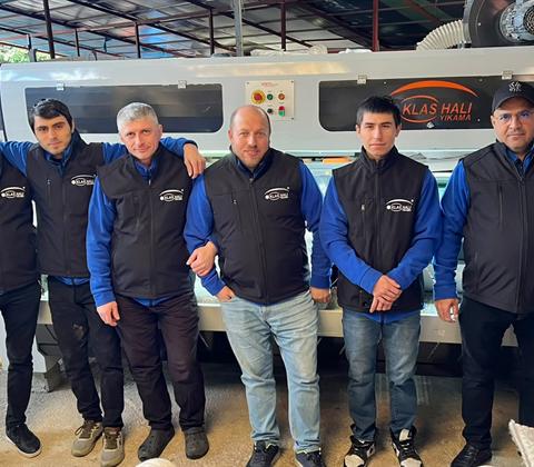 Klas Halı Yıkama ekibi tesisteki halı yıkama makinesinin önünde